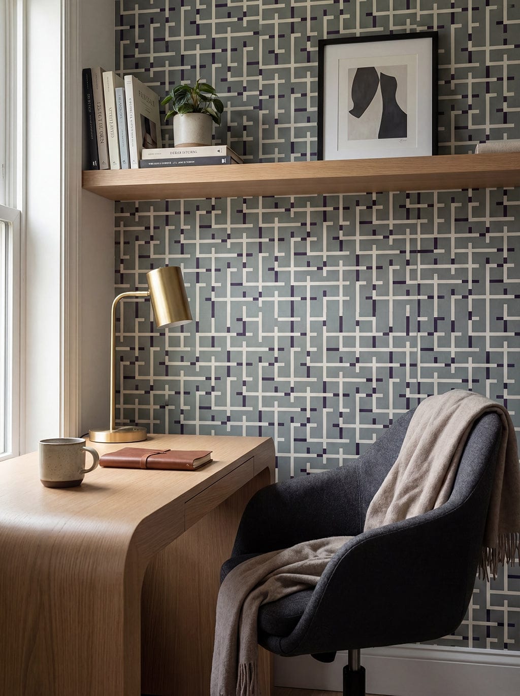 Home office with a desk, chair, lamp, and decorative wall tiles.