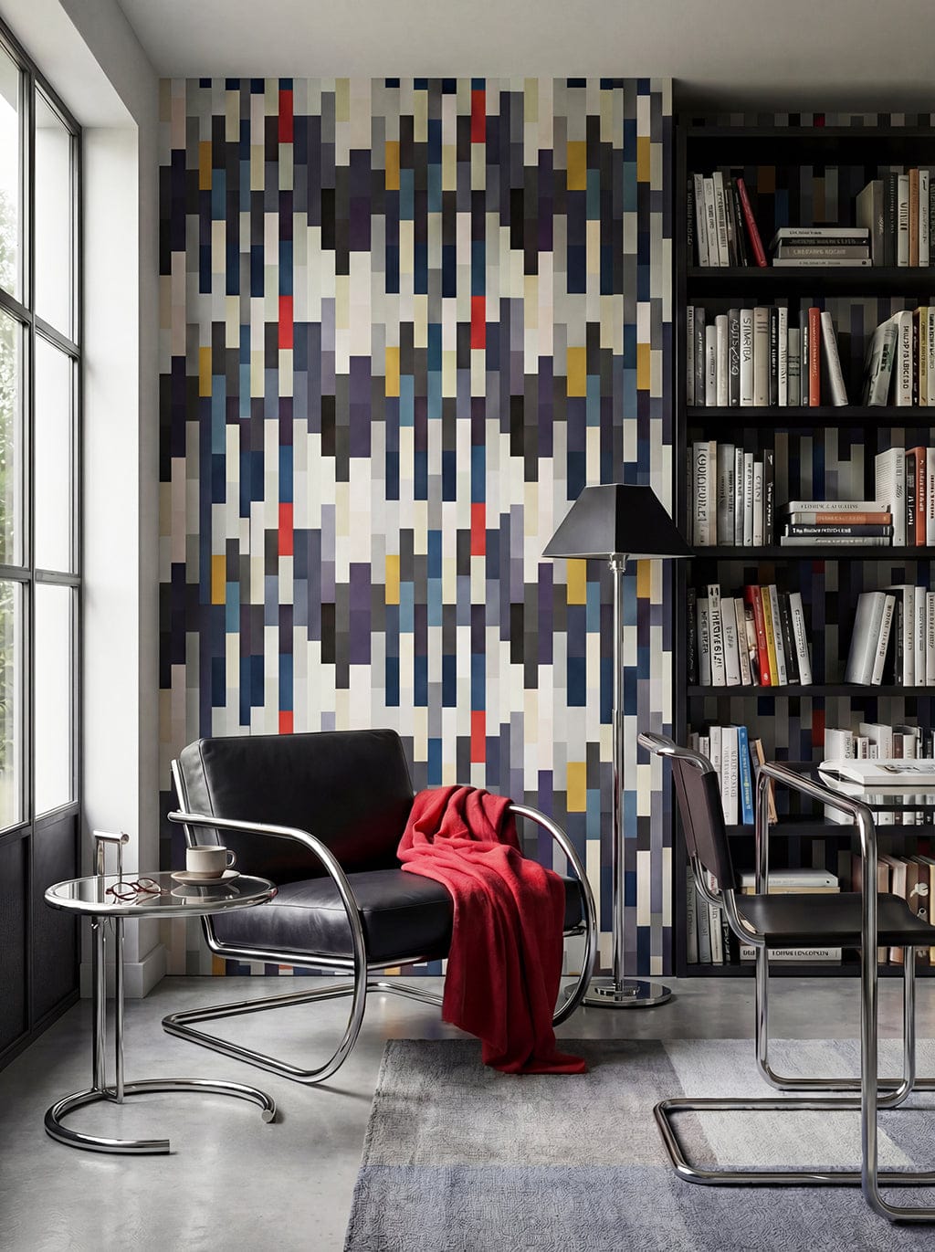 Modern living room with geometric wall design, black chair, and bookshelf.