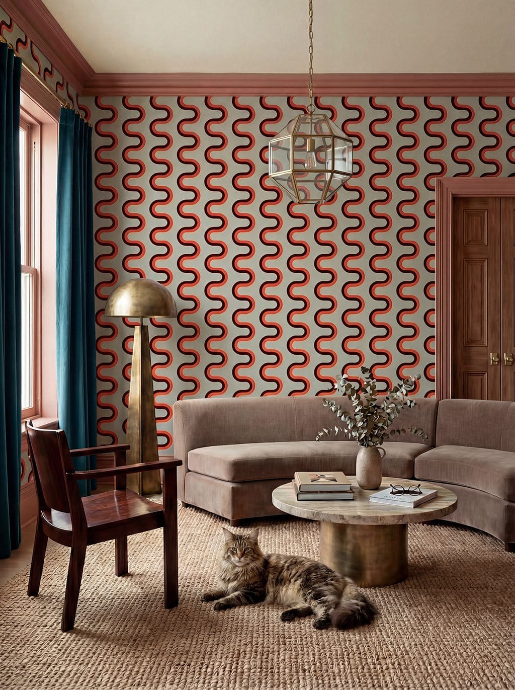 Living room with wavy red and white wallpaper, gray sofa, wooden chair, and a cat on the floor.